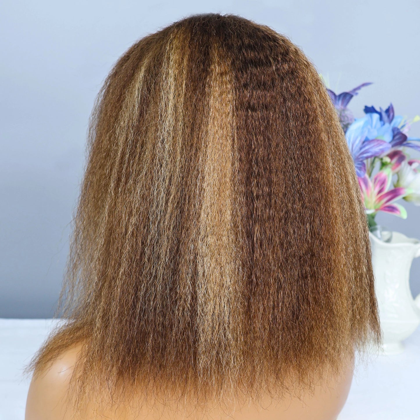 Chic and sophisticated human hair wig with transparent lace, showcasing a kinky straight bob style with beautiful highlights.