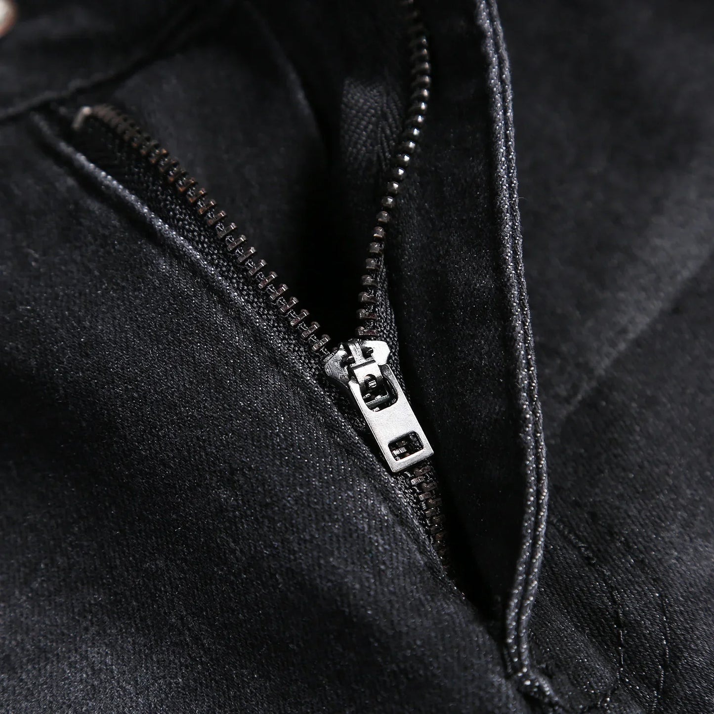 Detailed view of luxury men's pencil pants, showcasing high-quality softener denim with a stylish mid waist and classic stonewashed finish.