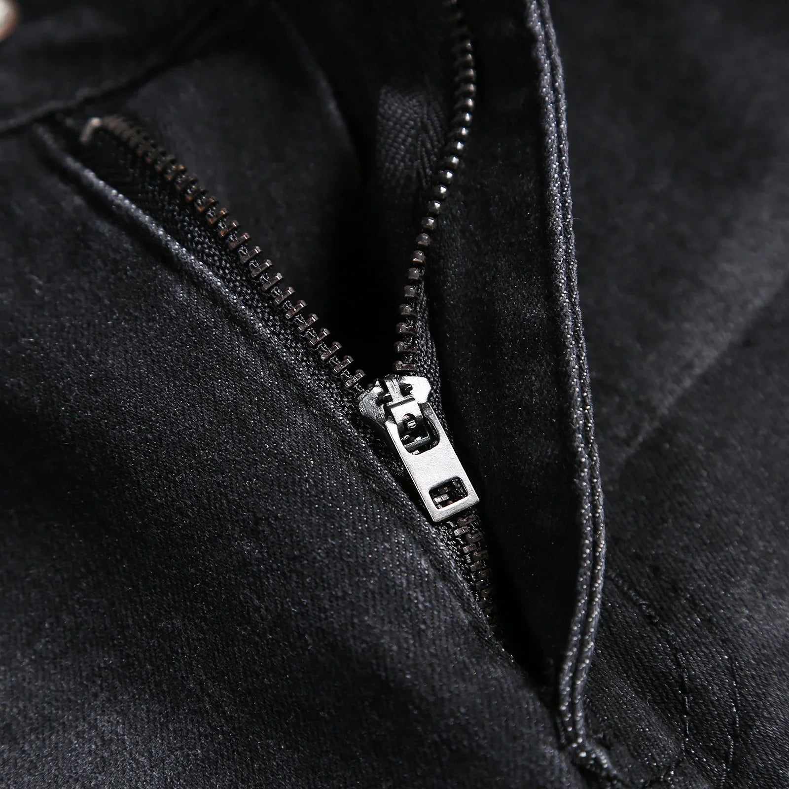 Detailed view of luxury men's pencil pants, showcasing high-quality softener denim with a stylish mid waist and classic stonewashed finish.