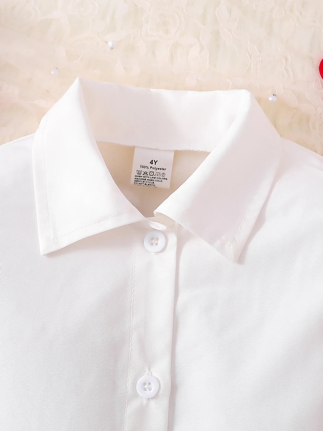 Charming close-up of the lace collar on a girls' red tank top, part of a luxurious 3-piece knitted ensemble for young fashionistas.