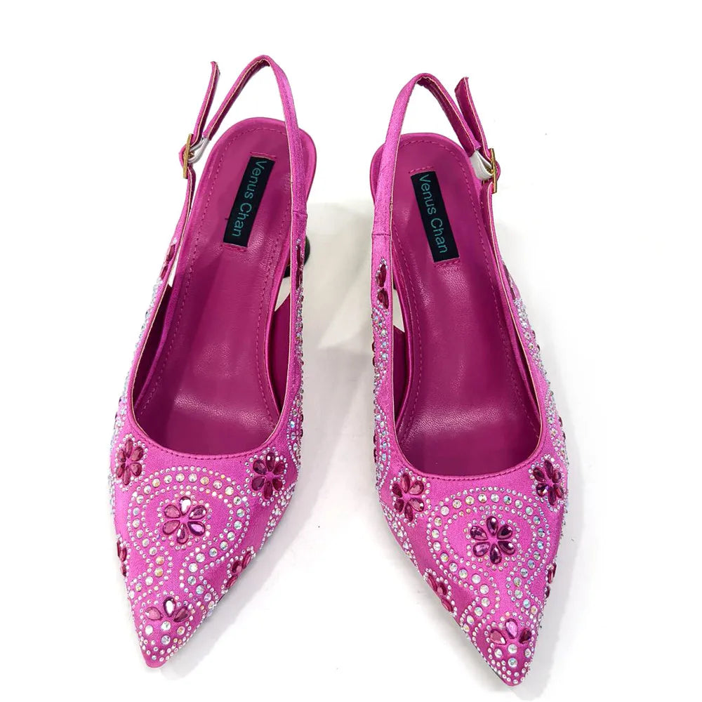 Stylish fuchsia bag with a metal handle and long chain shoulder strap, designed to complement the matching high heels for a sophisticated look.