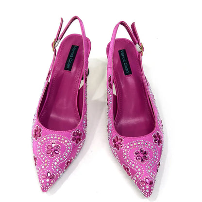 Stylish fuchsia bag with a metal handle and long chain shoulder strap, designed to complement the matching high heels for a sophisticated look.