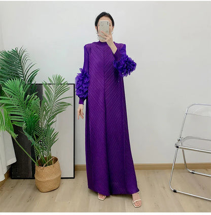 Stylish side view of a woman wearing a pleated maxi dress with petal sleeves, showcasing the graceful silhouette.