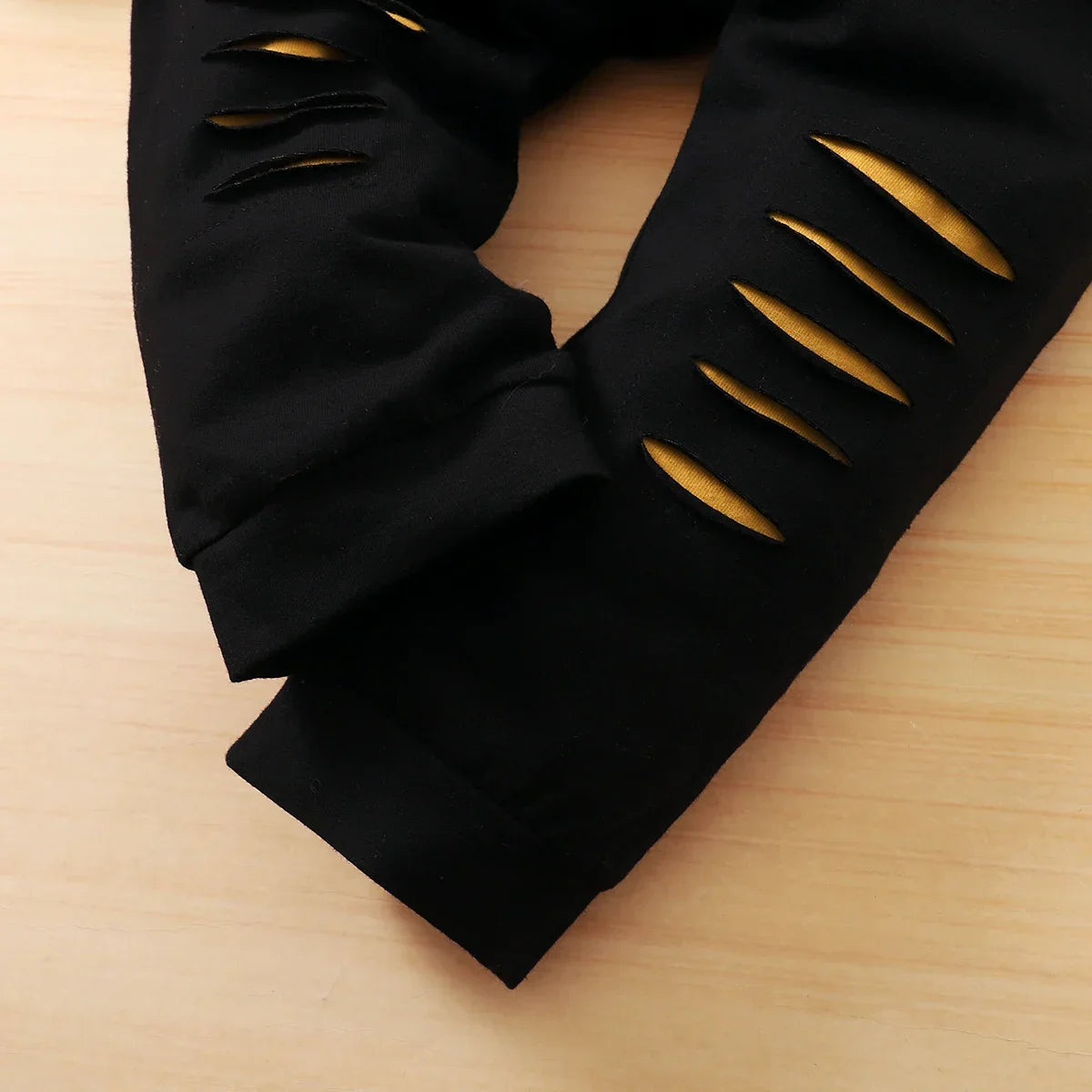 Close-up view of a trendy letter print design on a newborn boy's long sleeve top, part of a sophisticated 2-piece outfit for infants.