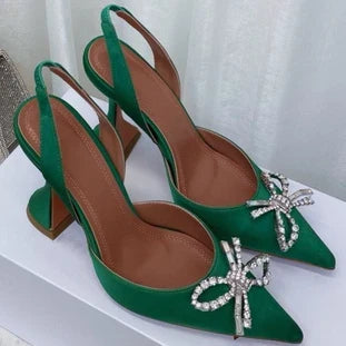 Close-up of luxury women's pointed toe stiletto heels sandals adorned with rhinestone bow detail, designed for style and elegance in summer parties.