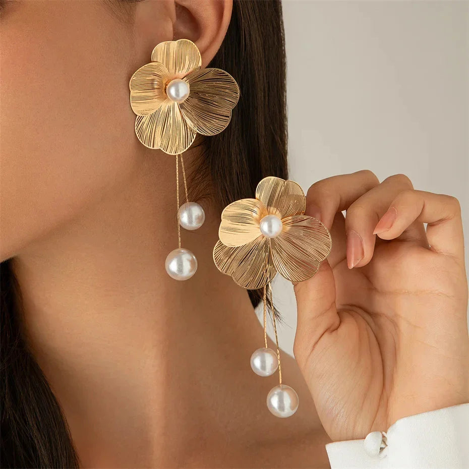 Sophisticated drop earrings with trailing tassels, embellished with floral motifs and radiant imitation pearls, a must-have accessory for contemporary women.