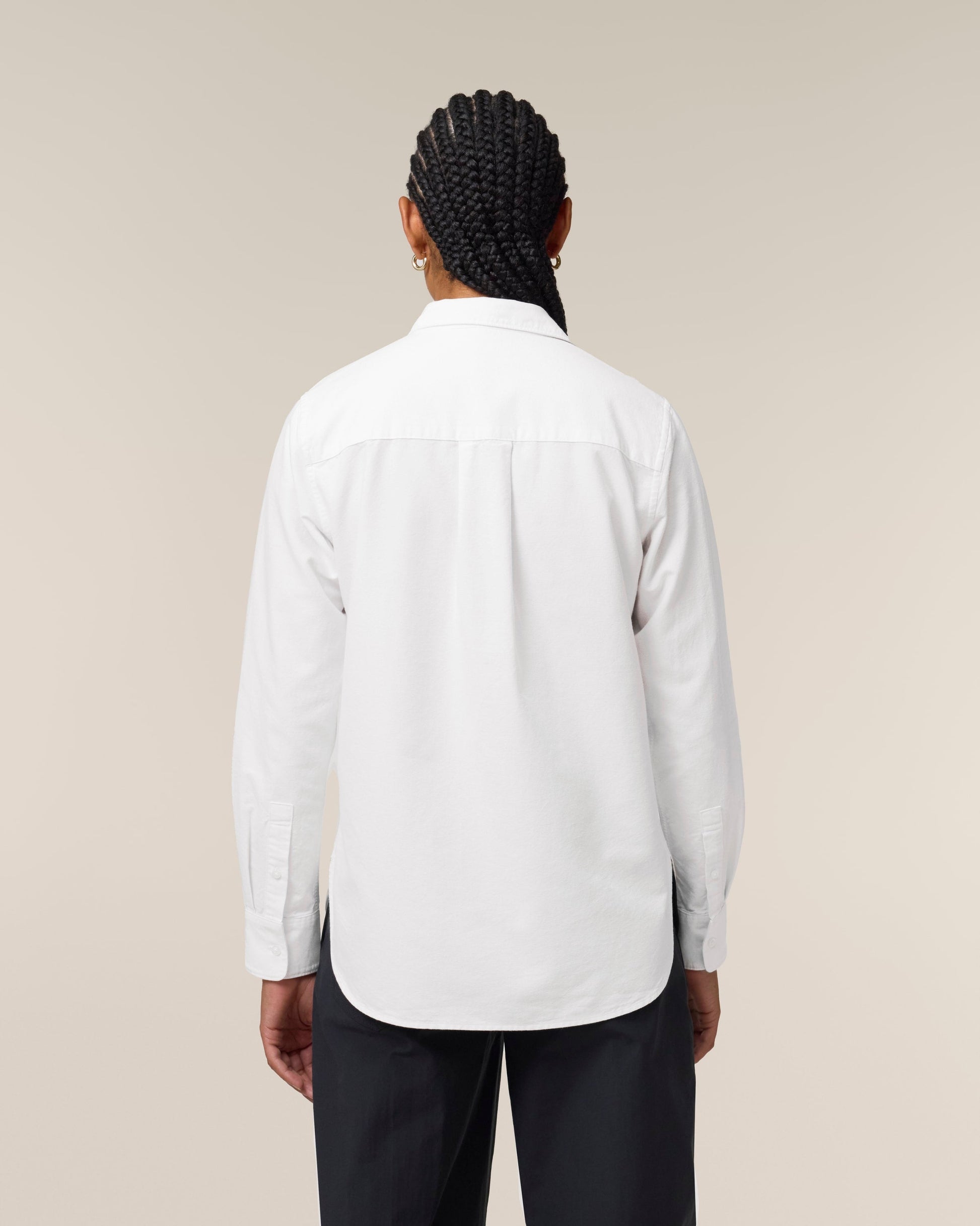 Side view of a womens organic cotton long sleeve shirt against a stylish backdrop, illustrating its contemporary and sophisticated design.