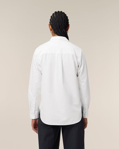 Side view of a womens organic cotton long sleeve shirt against a stylish backdrop, illustrating its contemporary and sophisticated design.
