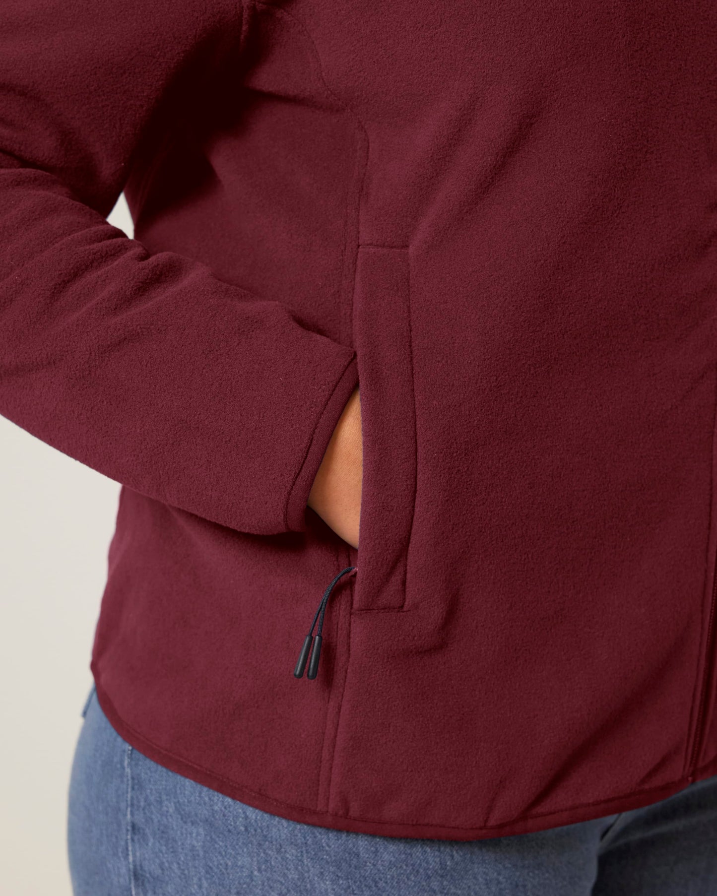 Versatile women's recycled polyester fleece jacket in a chic setting, illustrating its smooth texture and commitment to sustainability.