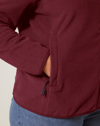 Versatile women's recycled polyester fleece jacket in a chic setting, illustrating its smooth texture and commitment to sustainability.