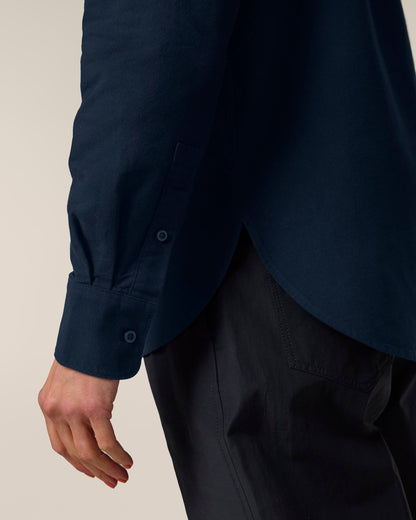 Model wearing an elegant organic cotton oxford long sleeve shirt, demonstrating comfort and style in a luxurious setting.