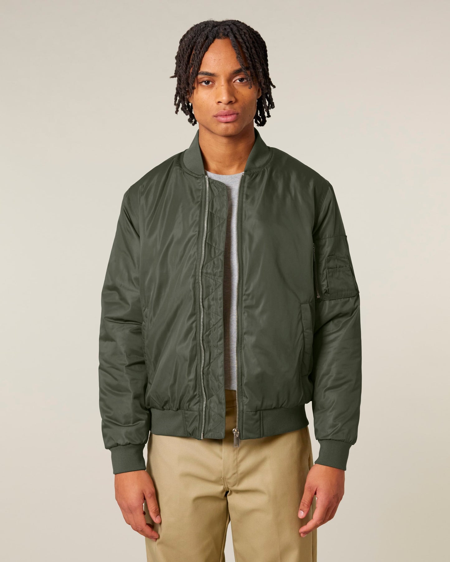 Model wearing a luxury unisex recycled bomber jacket, exuding elegance and style in an urban setting.