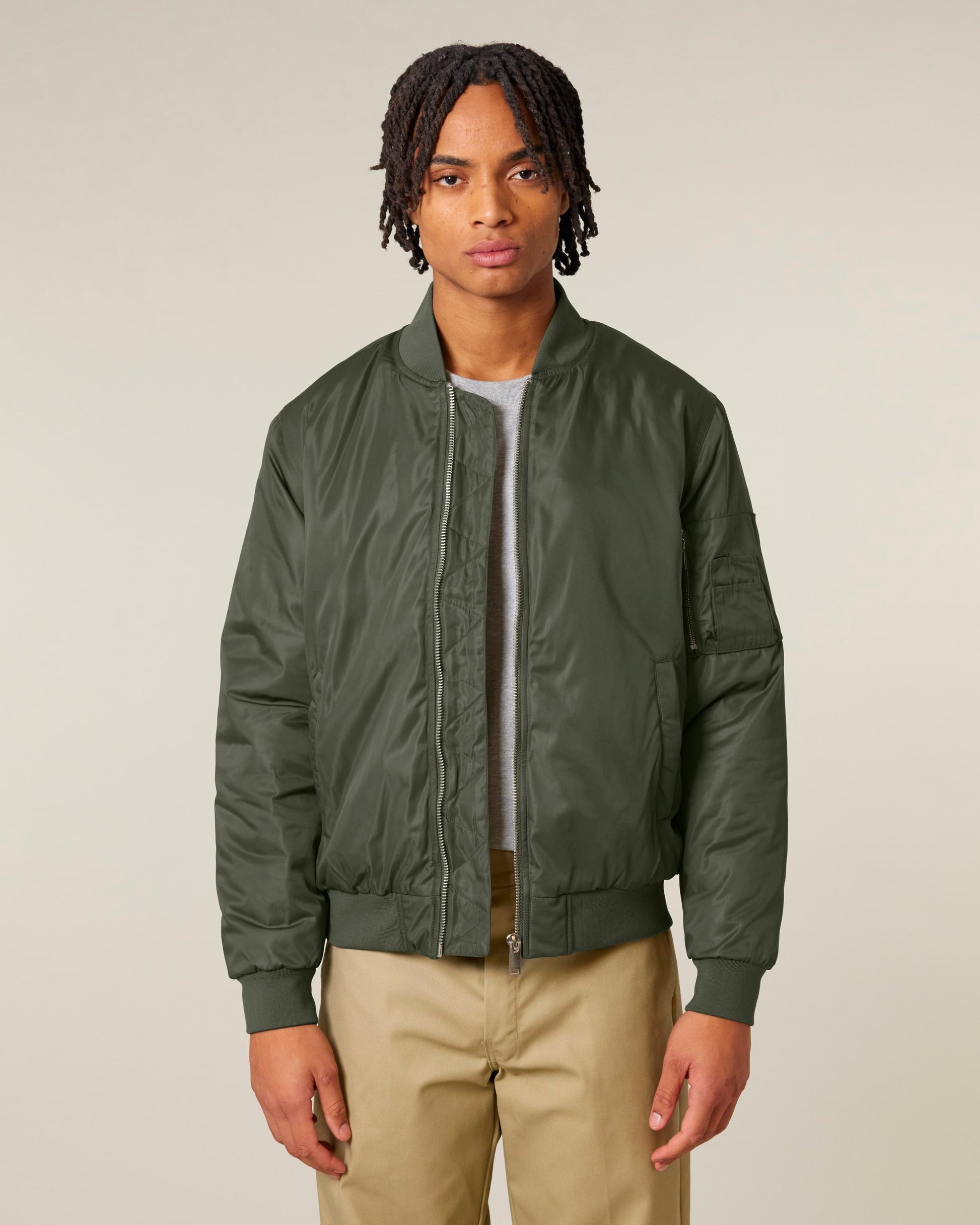 Model wearing a luxury unisex recycled bomber jacket, exuding elegance and style in an urban setting.