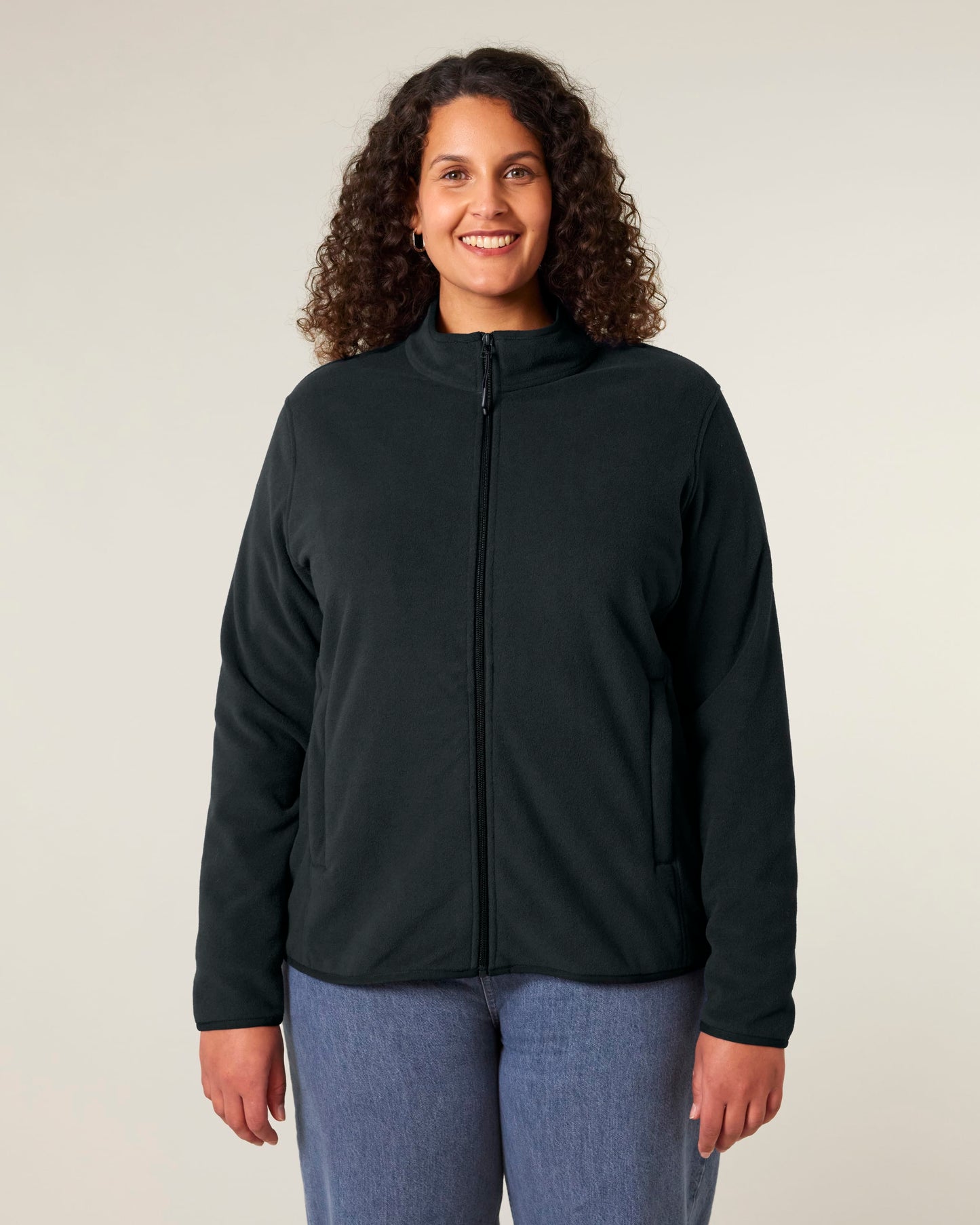 Model wearing a premium women's recycled polyester fleece jacket, demonstrating stylish layering options for winter and milder weather.