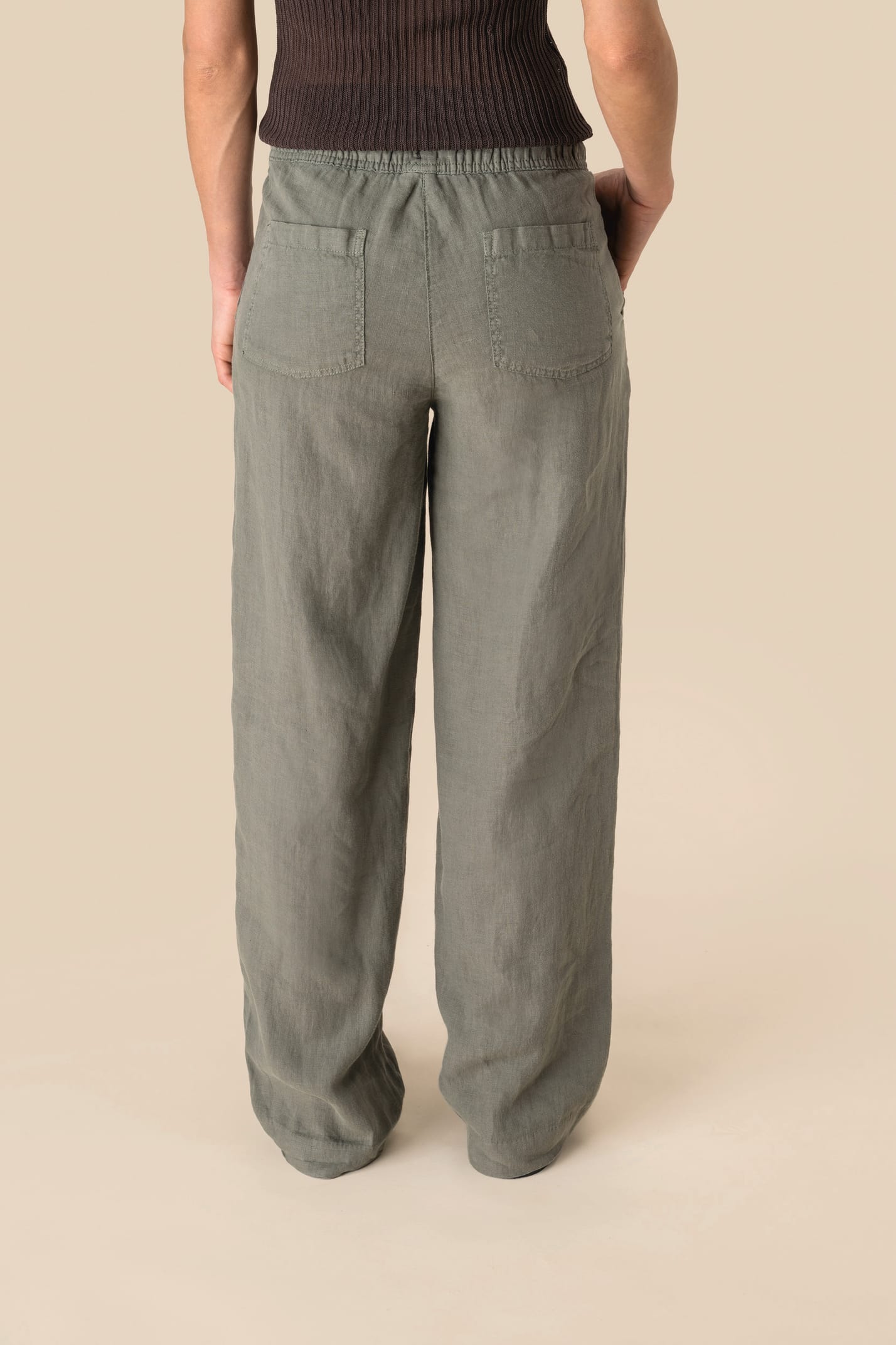 Stylish women's linen trousers in a sophisticated setting, illustrating their versatility for warm days and elevated casual outfits.