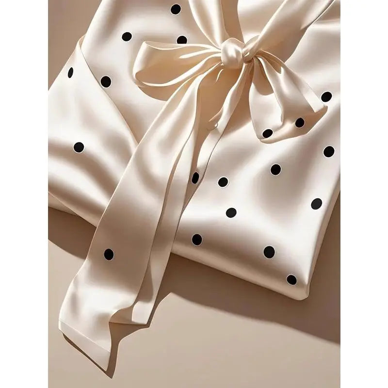 Elegant women's satin blouse featuring a stylish polka dot print, adorned with a chic lace-up bow, perfect for office wear.