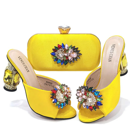 Stylish woman wearing yellow luxury rhinestone stiletto heels and matching evening bag at a glamorous party.