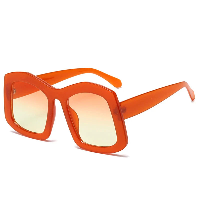 Close-up of luxury women's oversized square sunglasses with gradient orange lenses, showcasing UV400 safety feature and elegant polycarbonate design.