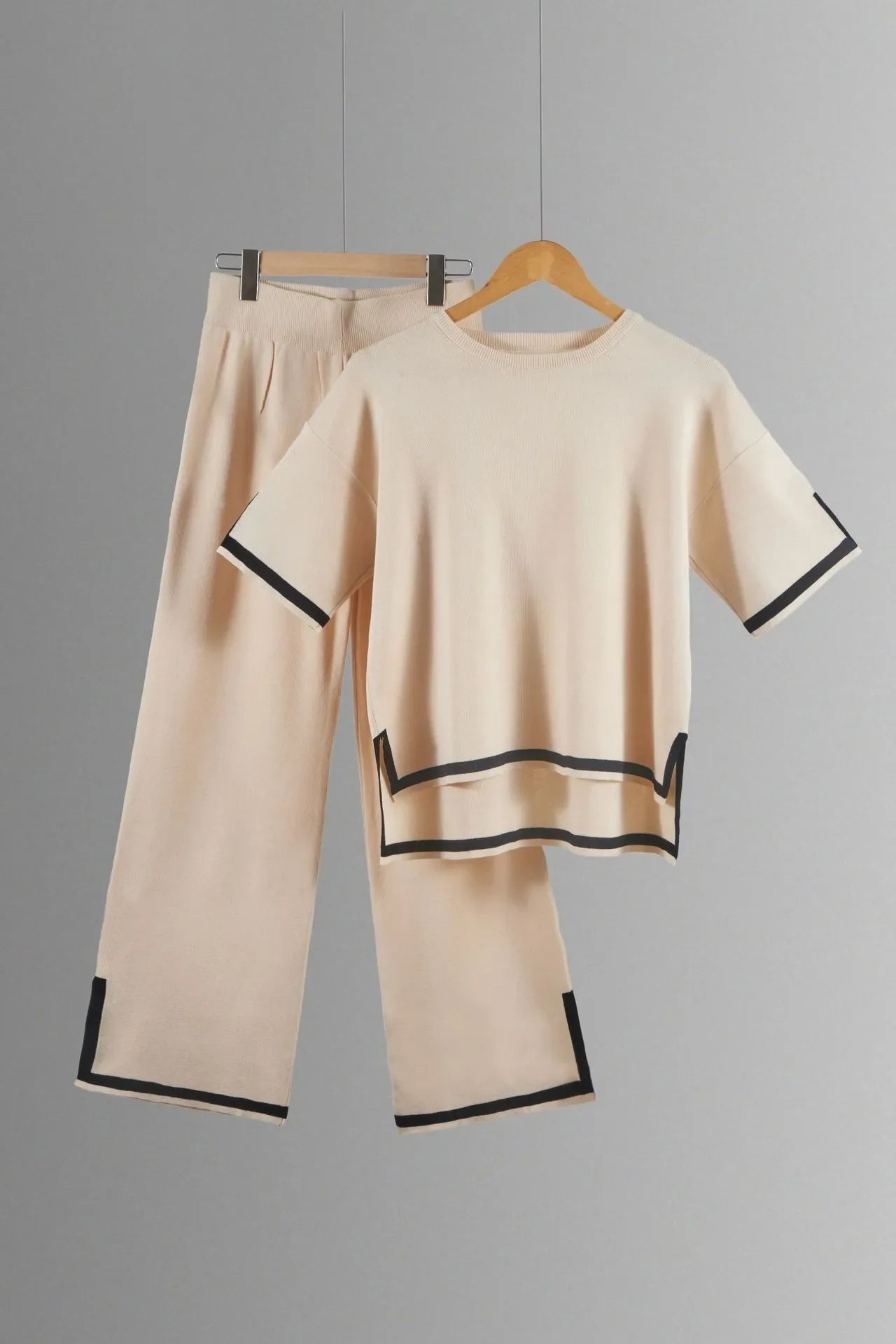 Ankle-length wide-leg trousers paired with a short-sleeved pullover in an elegant knitted suit, suitable for middle-aged women seeking timeless fashion.