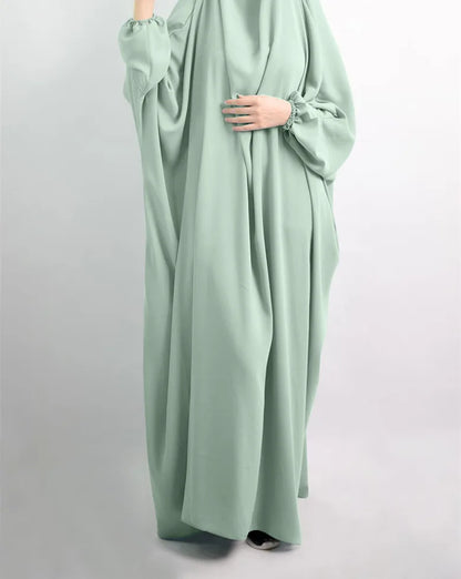 Elegant Muslim Abaya dress showcased on a mannequin, featuring a casual design made of soft polyester fabric with slight stretch, ideal for all-season wear.