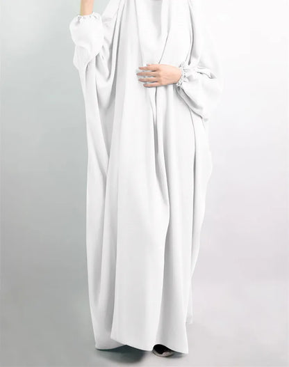 Model elegantly wearing a luxurious Muslim Abaya dress in a serene outdoor setting, perfect for casual and sophisticated occasions.