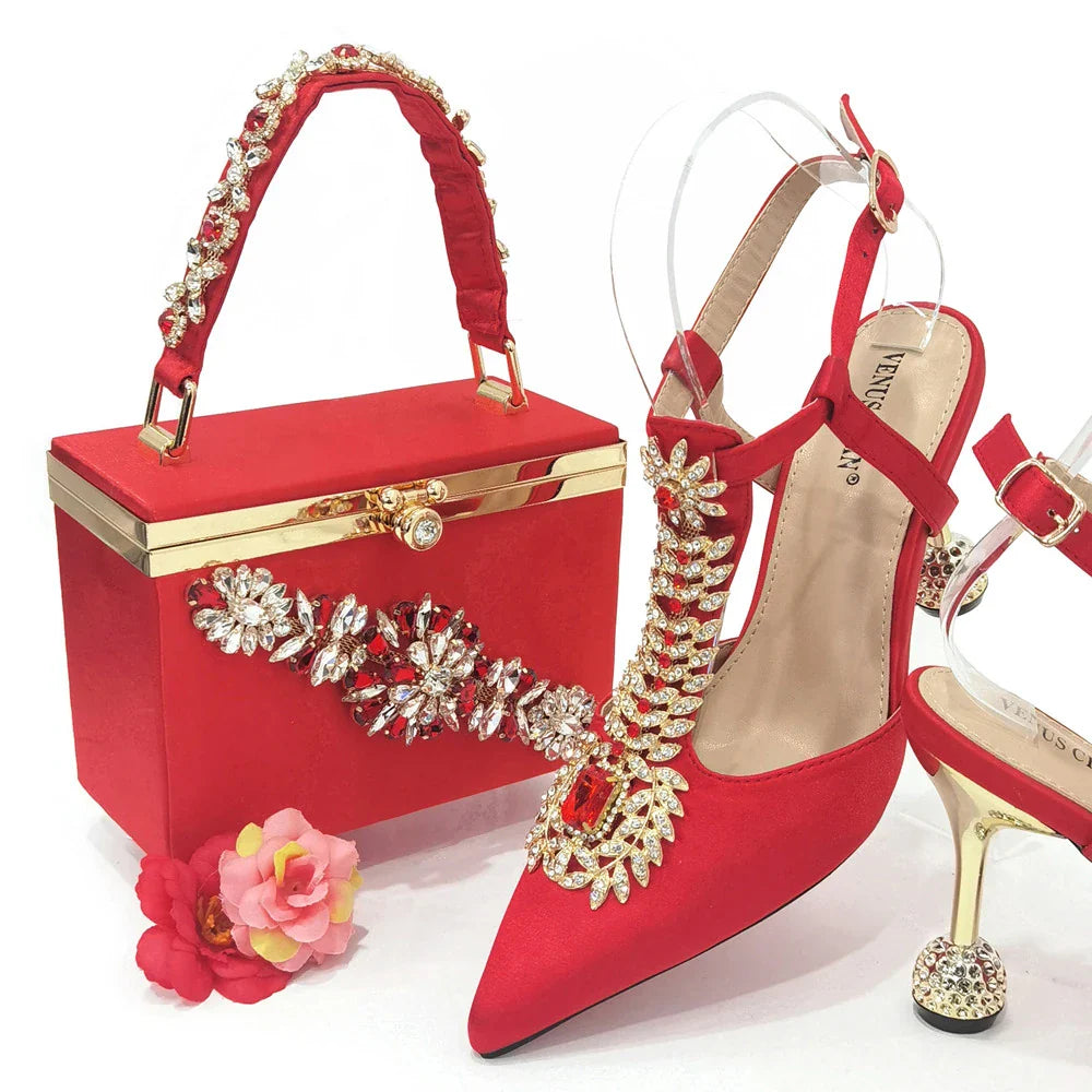 Luxurious women's red handbag with metal handle and long chain shoulder strap, designed to complement high heel shoes for a chic ensemble.