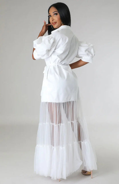 Close-up view of luxurious white lace fabric detail on an ankle-length women's dress, highlighting intricate lace patterns and sophisticated design.