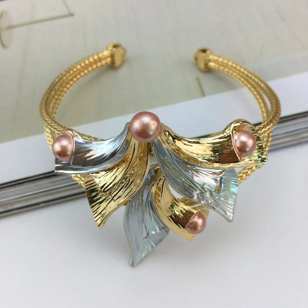 A stunning arrangement of a gold-plated jewelry set including a necklace, earrings, bracelet, and ring, showcasing a classic flower shape pattern.