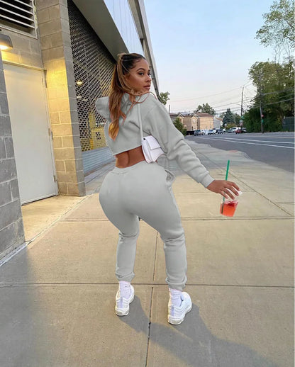 Luxury women’s pink fleece running set featuring a long sleeve cropped hoodie and jogger tracksuit, designed with a stylish spliced pattern.