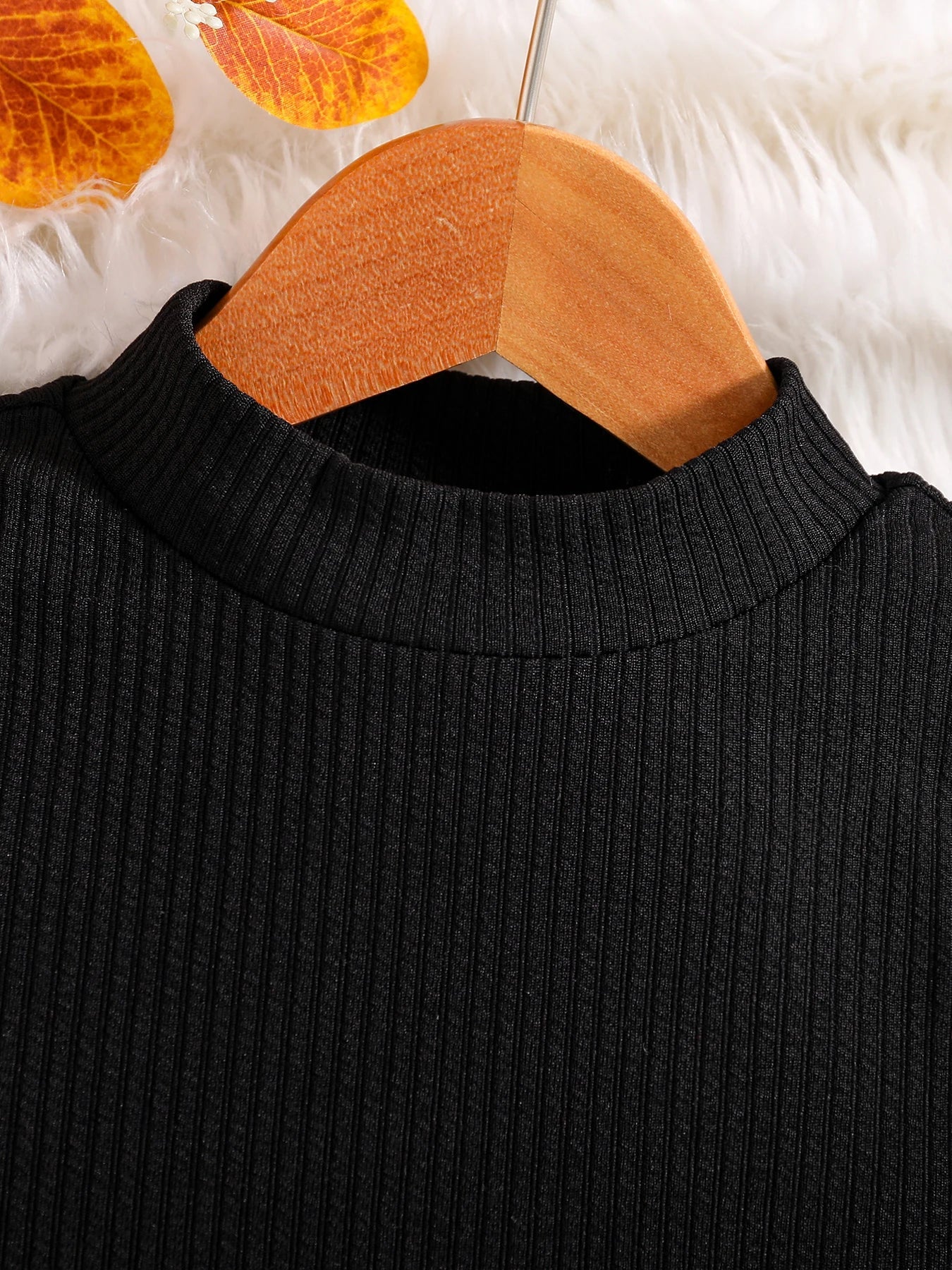 Elegant camouflage skirt designed for girls, perfect for autumn, complementing the black long-sleeved top in a luxury 2-piece outfit.