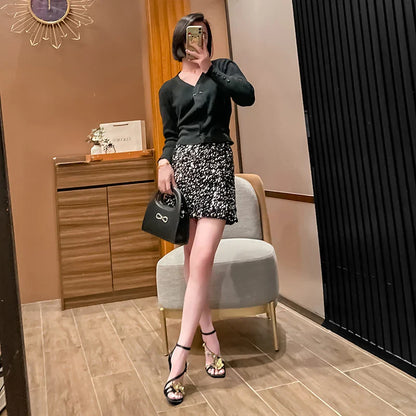 Sophisticated black high heel sandals featuring a delicate ankle strap and exquisite gold flower accents, designed for elegant styling.