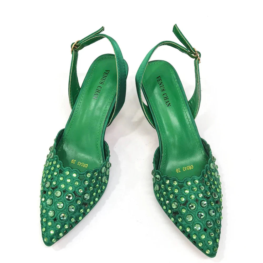 Close-up view of Venus Chan's high heel gold shoes showcasing intricate rhinestone detailing and a unique butterfly-knot design.