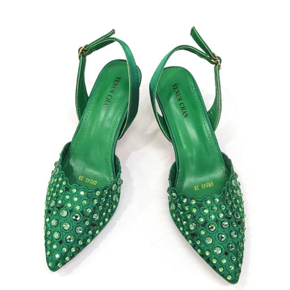 Close-up view of Venus Chan's high heel gold shoes showcasing intricate rhinestone detailing and a unique butterfly-knot design.