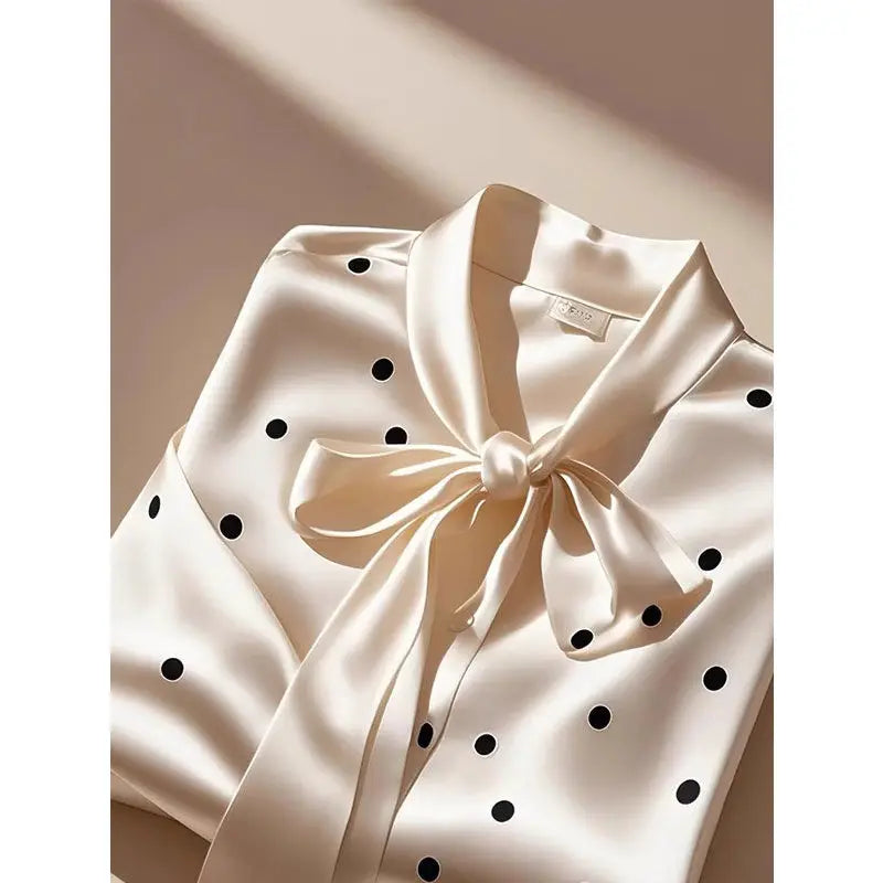 Stylish white polka dot satin blouse on a model, embodying office chic aesthetics with a loose fit and refined craftsmanship.