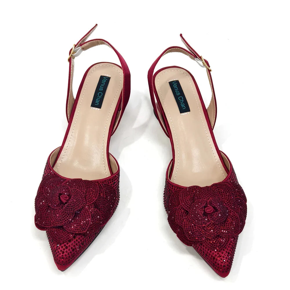 Fashion-forward pointed-toe pumps in a luxurious synthetic material, complemented by a chic handbag with a metal handle and chain strap.