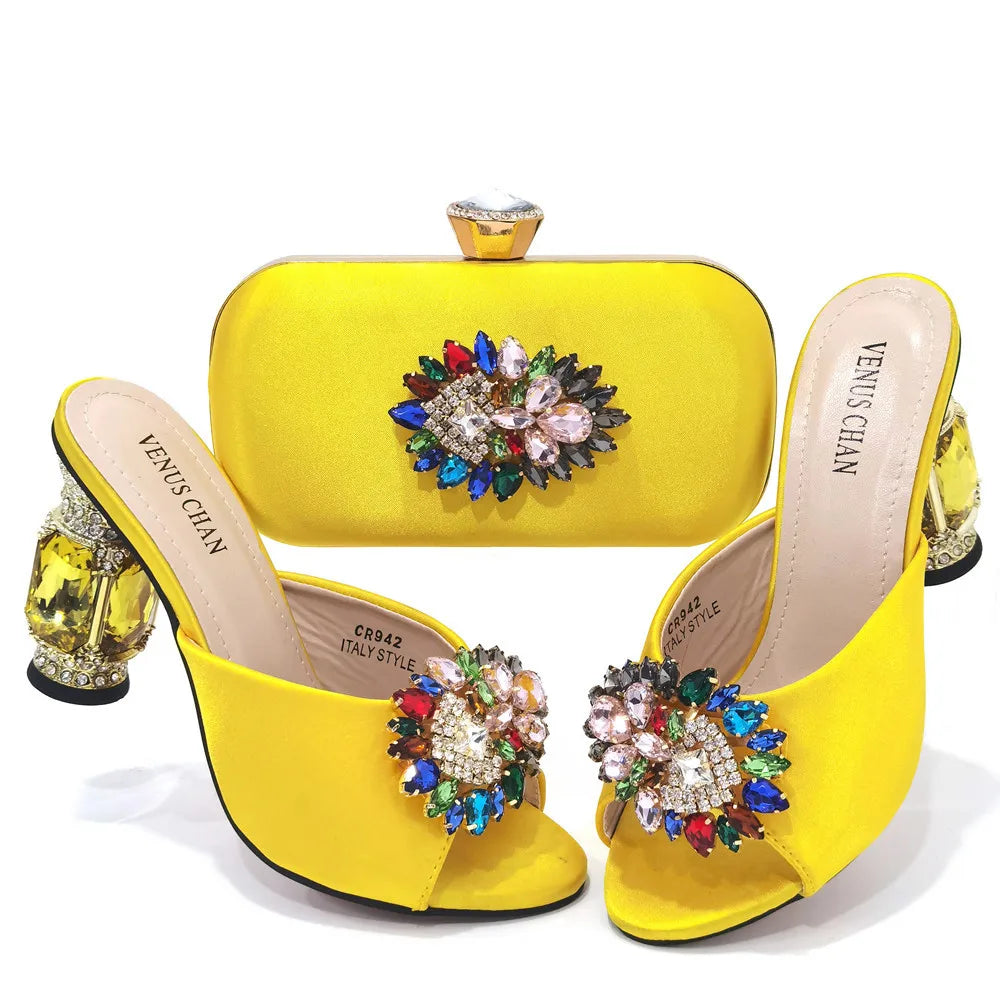 Stunning evening bag set featuring a decorative metal handle and long chain shoulder strap, designed to complement yellow rhinestone stiletto heels.