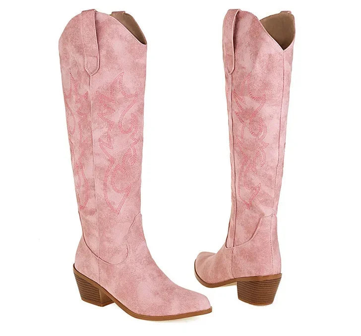 Close-up of luxurious brown PU leather knee-high boots, highlighting the sleek pointed toe and premium crafting.