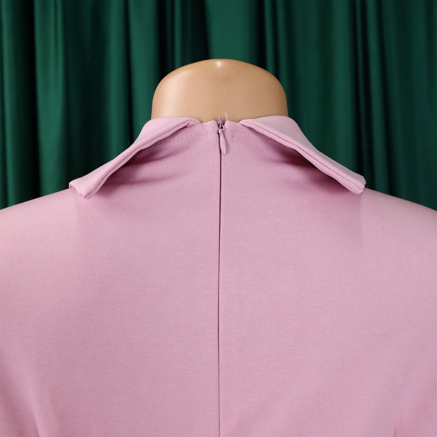 Back view of the luxurious women's knee-length dress highlighting the elegant zipper closure and beautifully crafted pleats perfect for evening wear.