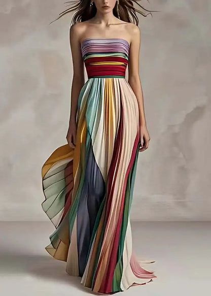 Sophisticated woman wearing a colourful striped sleeveless asymmetrical maxi dress, styled for a summer event.