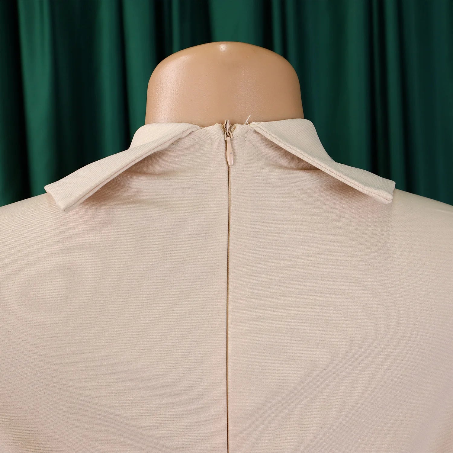 Detail shot of the pleats and zipper closure of a women's dress, highlighting the refined style and design elements for evening wear.