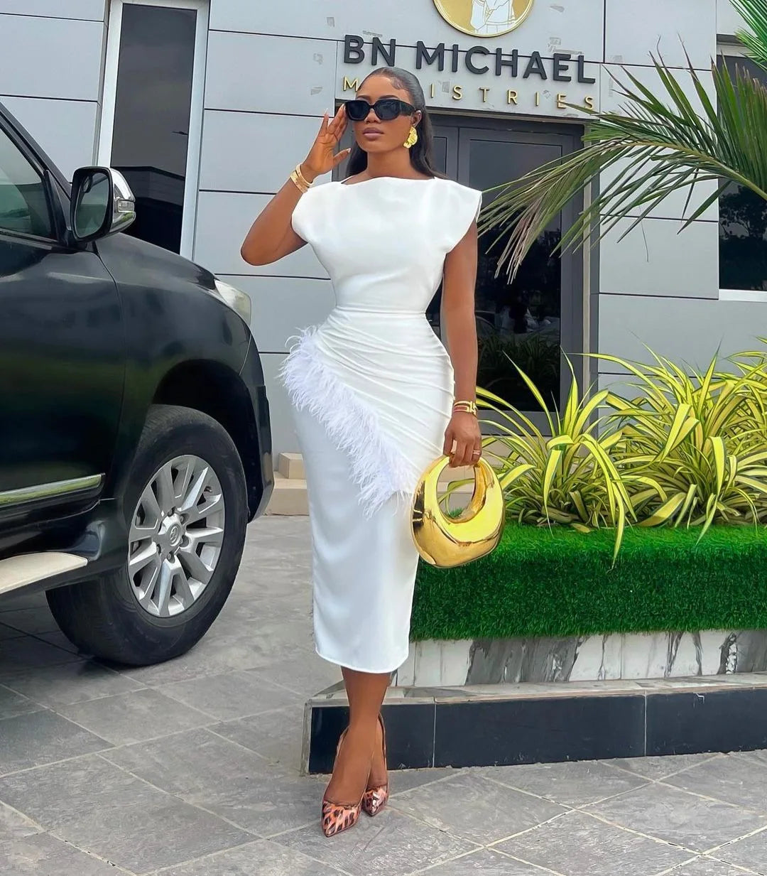 Chic women's ankle length office dress in a solid shade, showcasing a stylish O neck and a flattering slim fit, complemented by exquisite feather embellishments, ideal for professional settings.