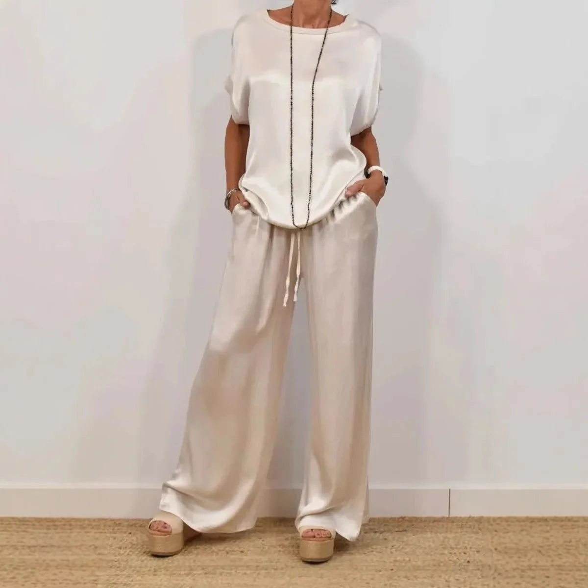 Chic and elegant summer outfit featuring a loose satin T-shirt and wide leg pants, perfect for stylish women seeking comfort.