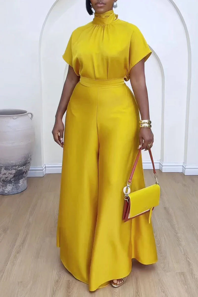Dramatic display of African women's fashion ensemble, combining a luxurious satin top with flattering high waist wide leg pants, ideal for graceful sophistication.