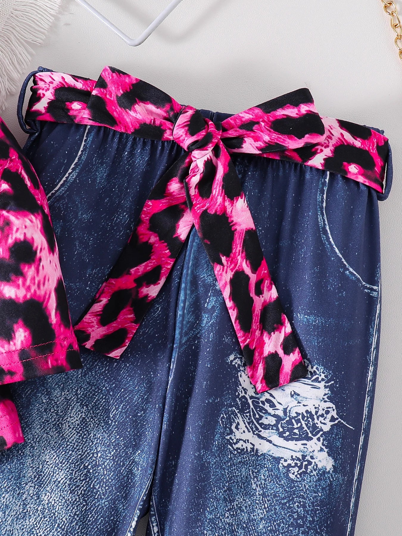Fashion-forward styling of a girls pink leopard print top paired with dark blue pants, showcasing an upscale look for toddlers aged 4-6 years.