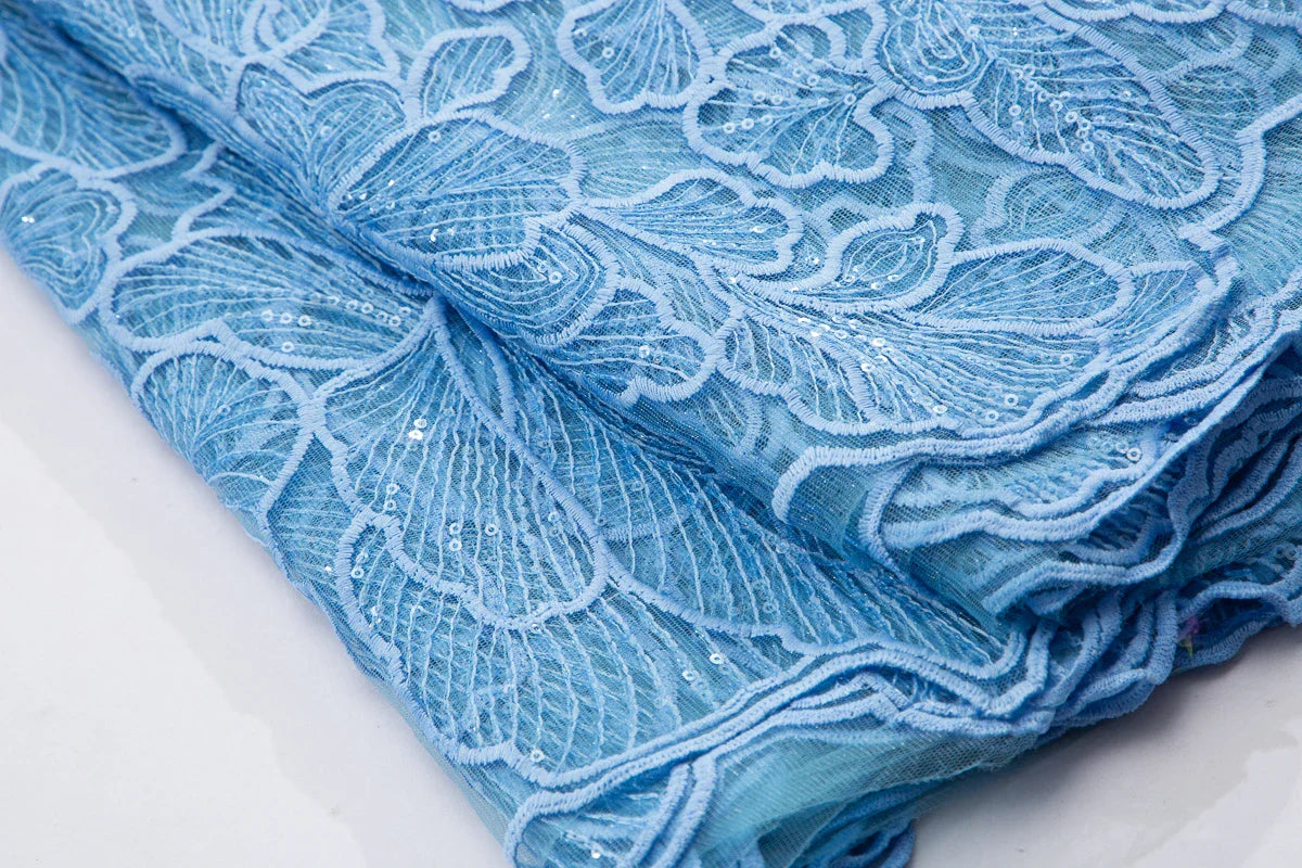 Stunning display of embroidered tulle lace fabric, 51-52 inches wide, designed for couture Nigerian wedding gowns.