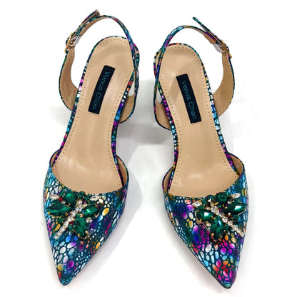 Chic matching champagne handbag with metal handle and long chain strap, designed to complement the pointed toe heels.