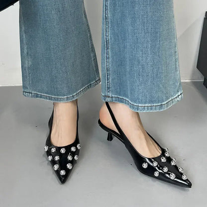 Elegant women's high heeled pumps with a sophisticated rivet detail and slip-on closure, ideal for casual summer outings.
