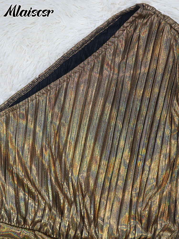 Close-up view of the luxurious fabric of the metallic gold one-shoulder evening dress, showcasing intricate pleating.