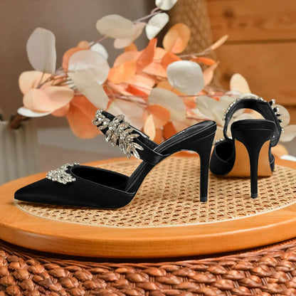 Sophisticated close-up of women's stiletto mules sandals featuring rhinestones and a sleek silk upper for a luxurious summer look.