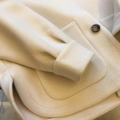 Close-up view of the soft woolen fabric of a plus-size winter coat, highlighting premium quality and cosy texture.